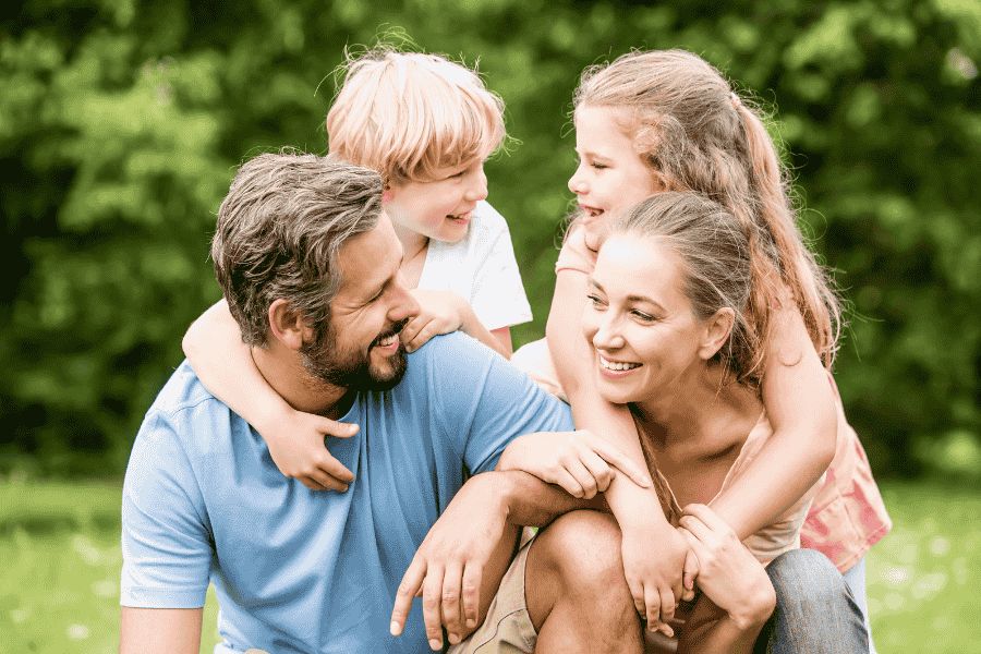 Familia sonriendo en un paisaje natural, disfrutando de su tiempo juntos.
